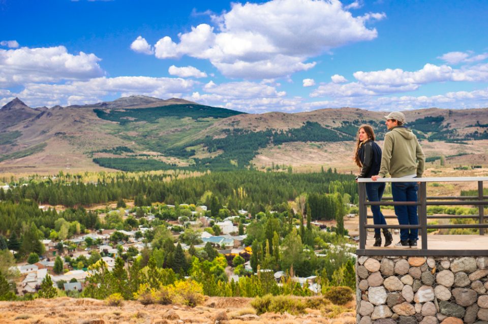 pareja observando desde un mirador con el fondo del pueblo y los cerros