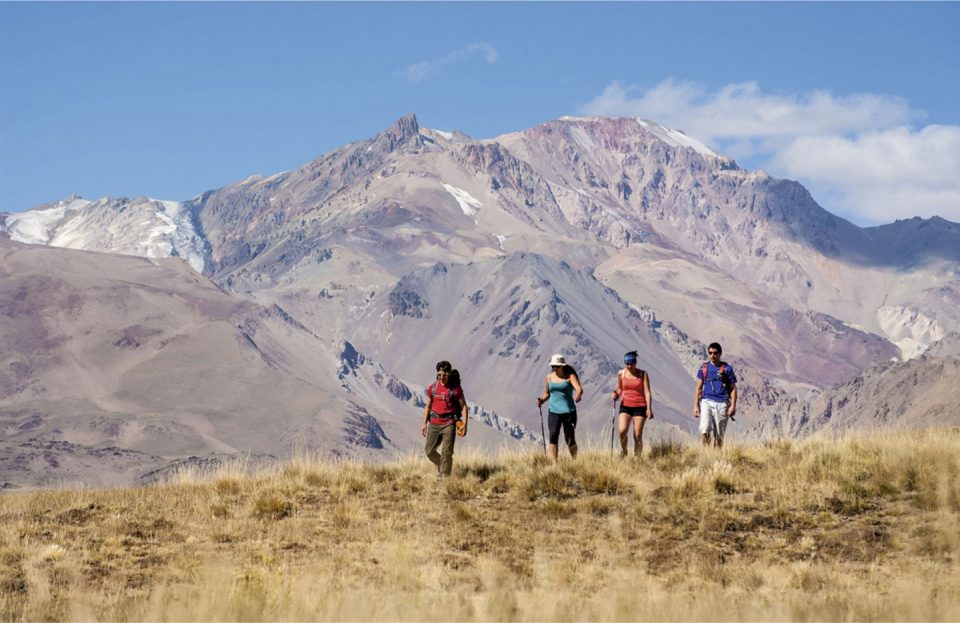 cuatro personas haciendo trekking en el norte neuquino con montañas de fondo