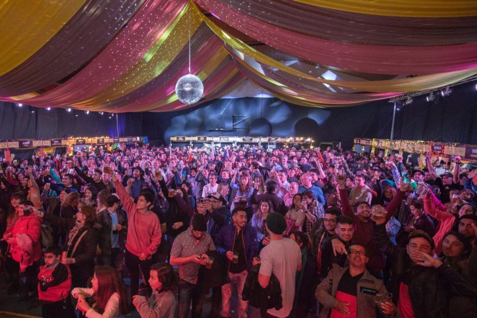 Fiesta nocturna en una globa con mucha gente bailando y bebiendo cerveza