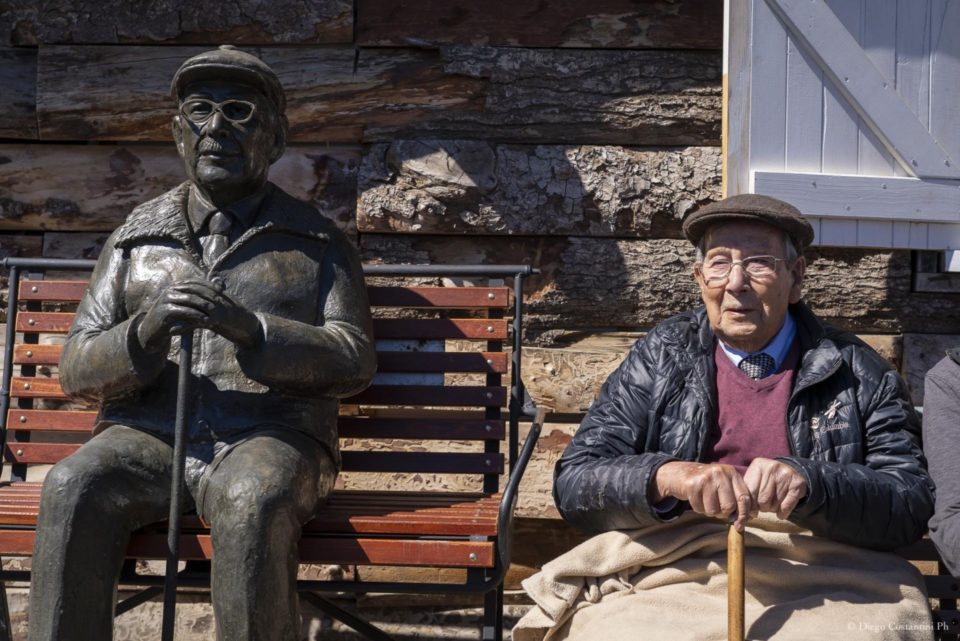 Américo Astete junto a su escultura, homenaje de Chapelco a sus pioneros en el histórico Refugio Graeff 