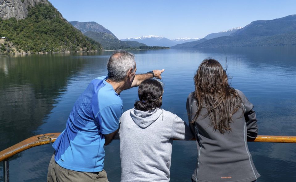 personas de espalda en un mirador viendo el Lago y las montañas de fondo
