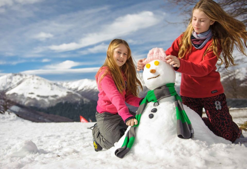 Niñas haciendo un  muñeco de nieve en Cerro Bayo